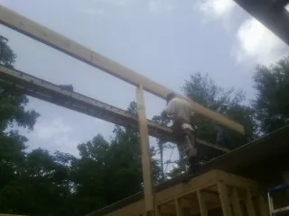 Carpenter setting a ridge beam over a new addition frame — Ice Dam Removal by Roofing Brothers in Dale