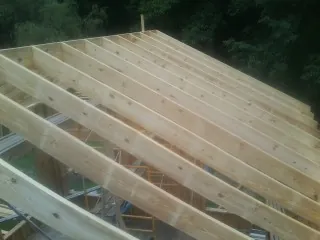 New roof rafters set over an addition before sheathing in Dale