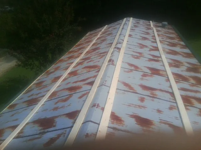 Rusted metal roof panels with new wood purlins before replacement — Storm Damage Roof Repair in Dale by Roofing Brothers